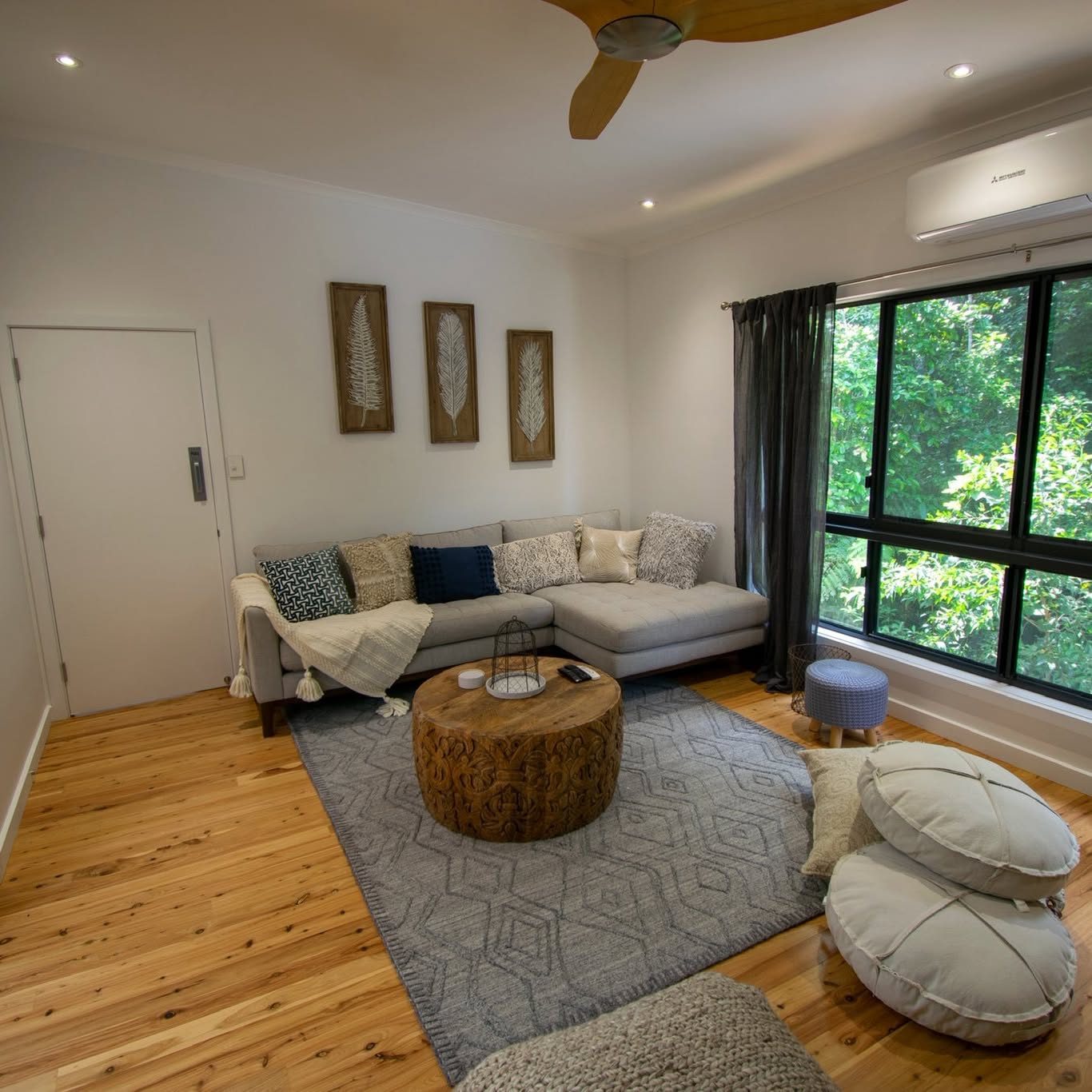 A media room with a timber ceiling fan and a split system on the wall