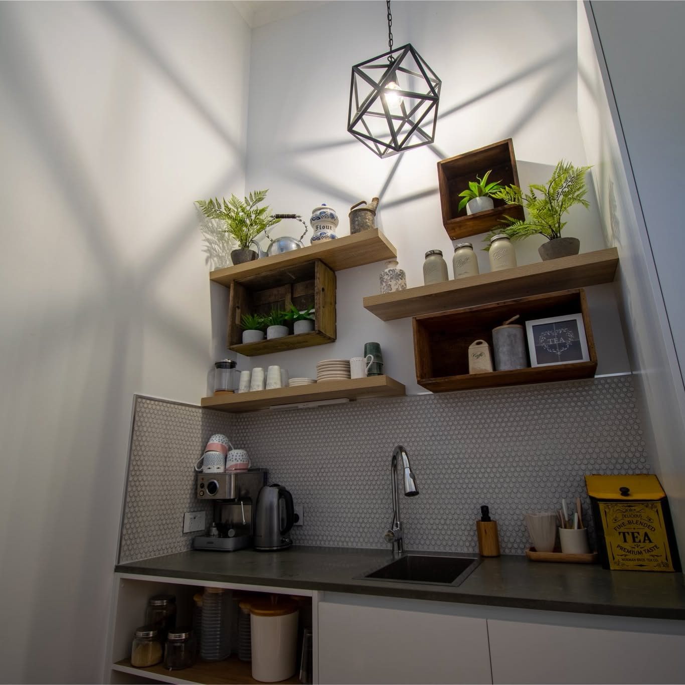 A geometric cage pendant throwing a star pattern across the pantry wall