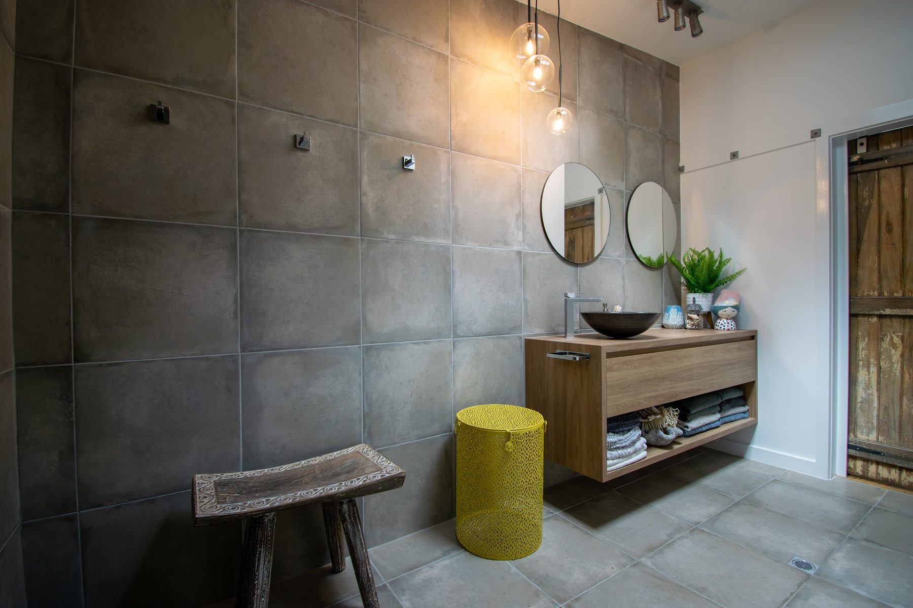 The bathroom with cluster pendants above the vanity and adjustable spots overhead